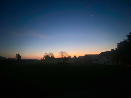 Dämmerung vor Sonnenaufgang mit orangem Streifen am Horizont 