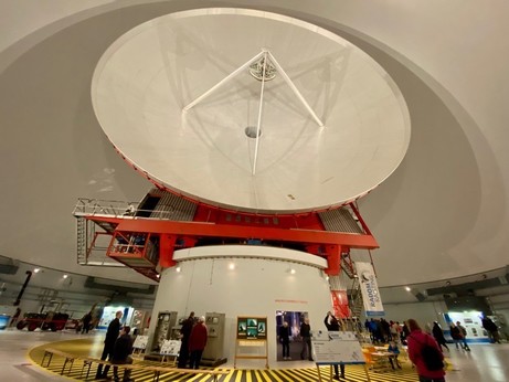 eine riesige Satellitenschüssel mit Drehgestell drunter in einer riesigen weißen Kuppel 