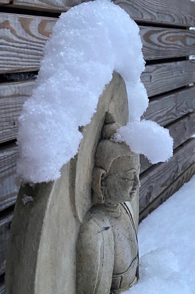 auf der Figur eines sitzenden Buddha hat sich Schnee angehäuft. An der Stirn ist ein richtiger Überstand entstanden 