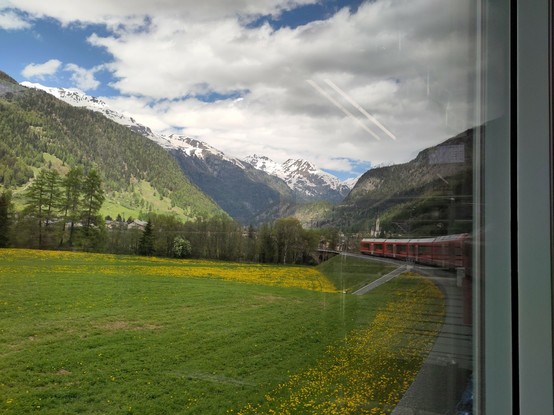 Foto. Ein roter Zug in Berglandschaft.