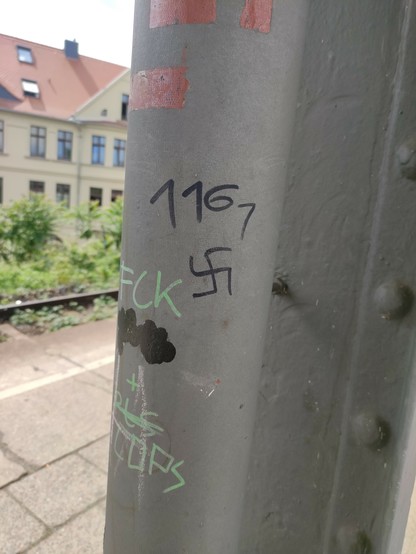 Foto von einem Hakenkreuz an einem Pfeiler auf Gleis 1 im Bahnhof Magdeburg Neustadt. Darüber ist der Zahlencode 1161 für Anti-Antifa.