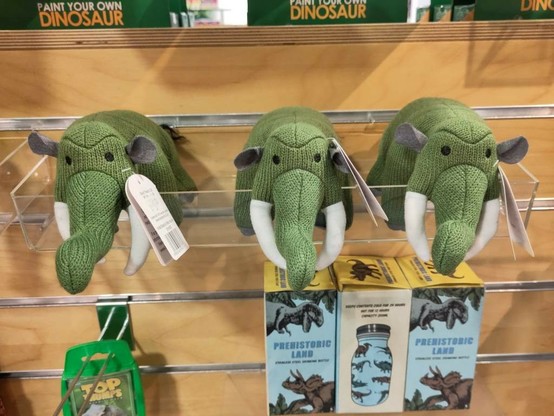 Drei grüne Stofftiere, die Mastodonten darstellen sollen.