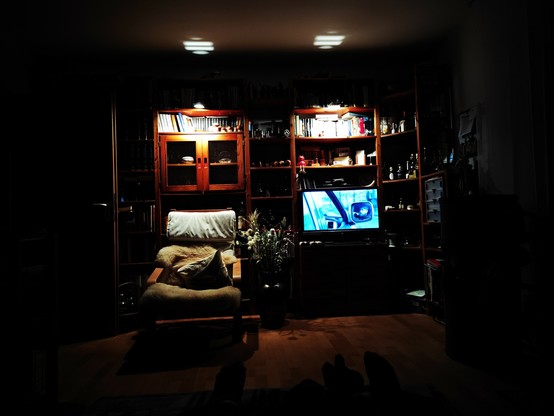 Wohnzimmer Bücherregal mit dem Fernsehgerät in schummeriger Beleuchtung. 