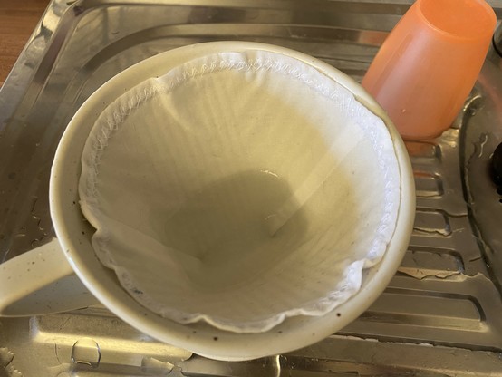Keramikkaffeefilterhalter mit aus weißem Stoff genähtem Stofffilter. 
