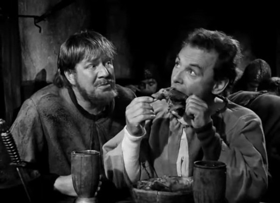 black and white screenshot from the film,
Jof (Nils Poppe) eating a chicken leg.
