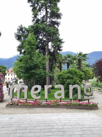 Das Wort Meran in großen Buchstaben vor einem Baum