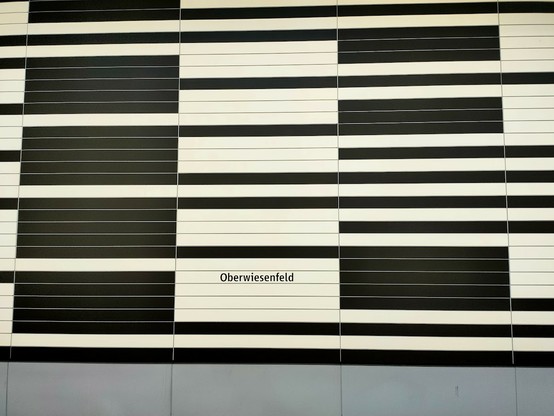 U-Bahn München Station Oberwiesenfeld Schwarz-weisses Labyrinth mit kleiner schwarzer Schrift