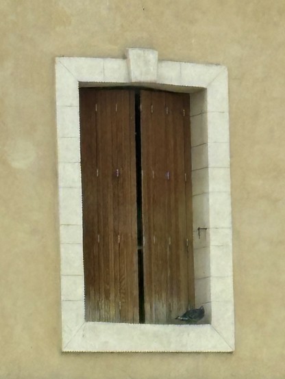 Fenster mit geschloßenen Holzfensterläden und weißer Umrandung, irgendwo in Frankreich 