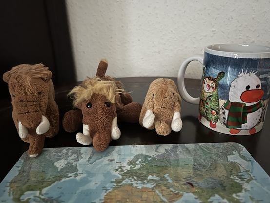 Die drei plüschigen Mammuts mit einem leeren Frühstücksbrettchen und einer Tasse