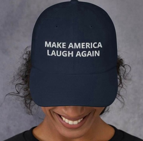 Black Woman wearing a dark baseball cap with the phrase 