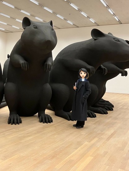 Mehrere riesige schwarze Rattenskulpturen im Kreis, Köpfe nach aussen. Davor eine hslb so grosse Frau