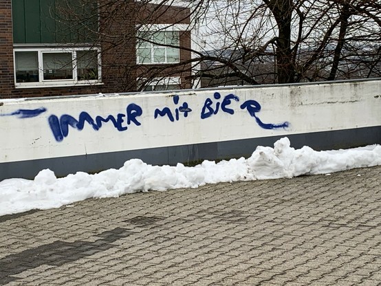 Graffiti on a white wall reads 