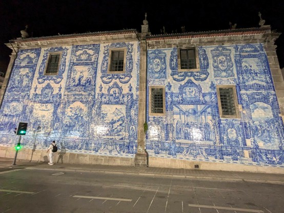 eine nachts angestrahlte Wand einer Kirche, die komplett mit blau bemalten Kacheln verziert ist 