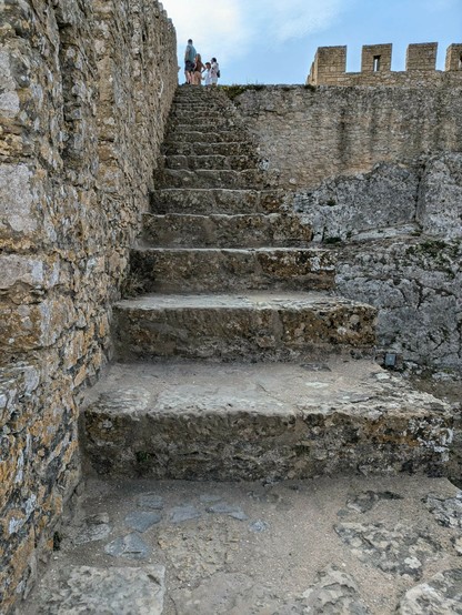 felsige Stufen führen auf die Burgmauer. es ist kein Geländer auf der Seite vorhanden, auf der es steil nach unten geht