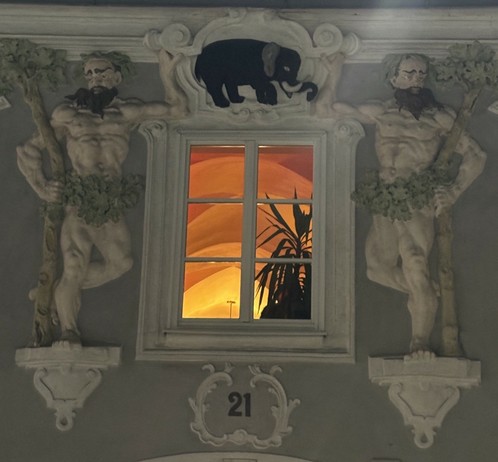 beleuchtetes Fenster auf Stuckfassade, Hauptplatz 21 Linz, daüber Elefant mit interessanter Geschichte
(Wikipediaeintrag Soliman, erster Elefant in Wien) 