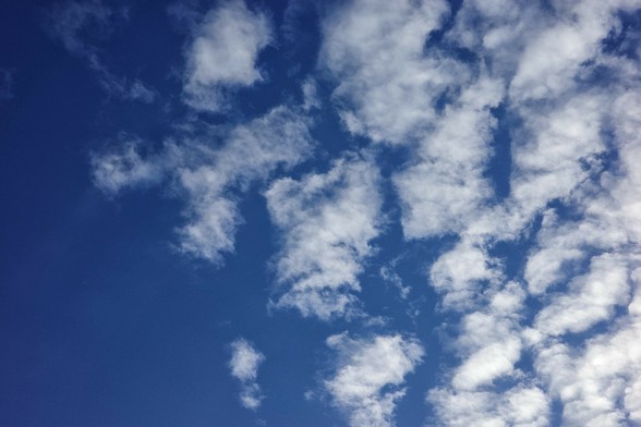 am blauen Himmel kommen von rechts weiße lockere Wolken 