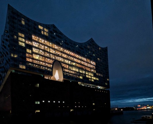 beleuchtete Elbphilharmonie im fast Dunklen von der Seite