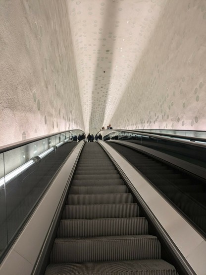die in sich gebogene Rolltreppe nach oben 