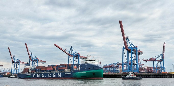 ein LNG betriebenes Contaierschiff mit je einem Schlepper vorne und hinten 