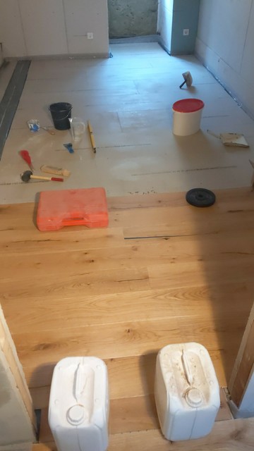 Ein kleines Zimmer. Der Estrichboden ist sichtbar, ein Drittel des Bodens ist mit Holzdielen belegt.