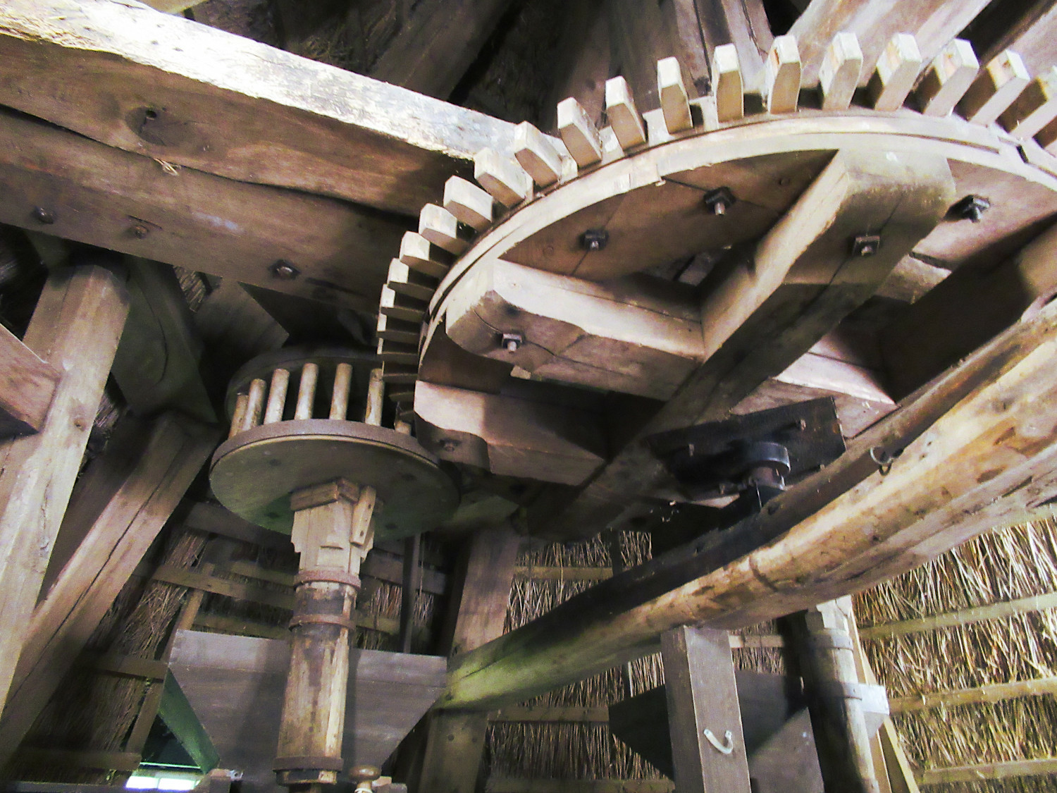 Blick in das Innere einer alten Windmühle. Große Zahnräder und Balken aus Holz dominieren das Bild. Blick in das Innere einer alten Windmühle. Große Zahnräder und Balken aus Holz dominieren das Bild.