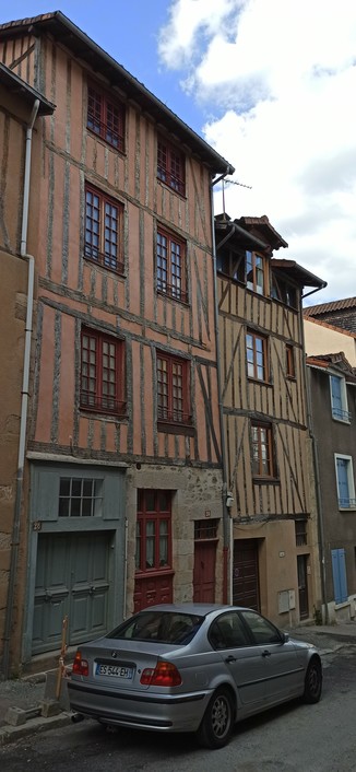 Fachwerkhäuser, gestrichen in leichten rotocker und vier rot gestrichene Holzfenster, die geteilt sind und je Hälfte 10 Butzenscheiben enthalten.