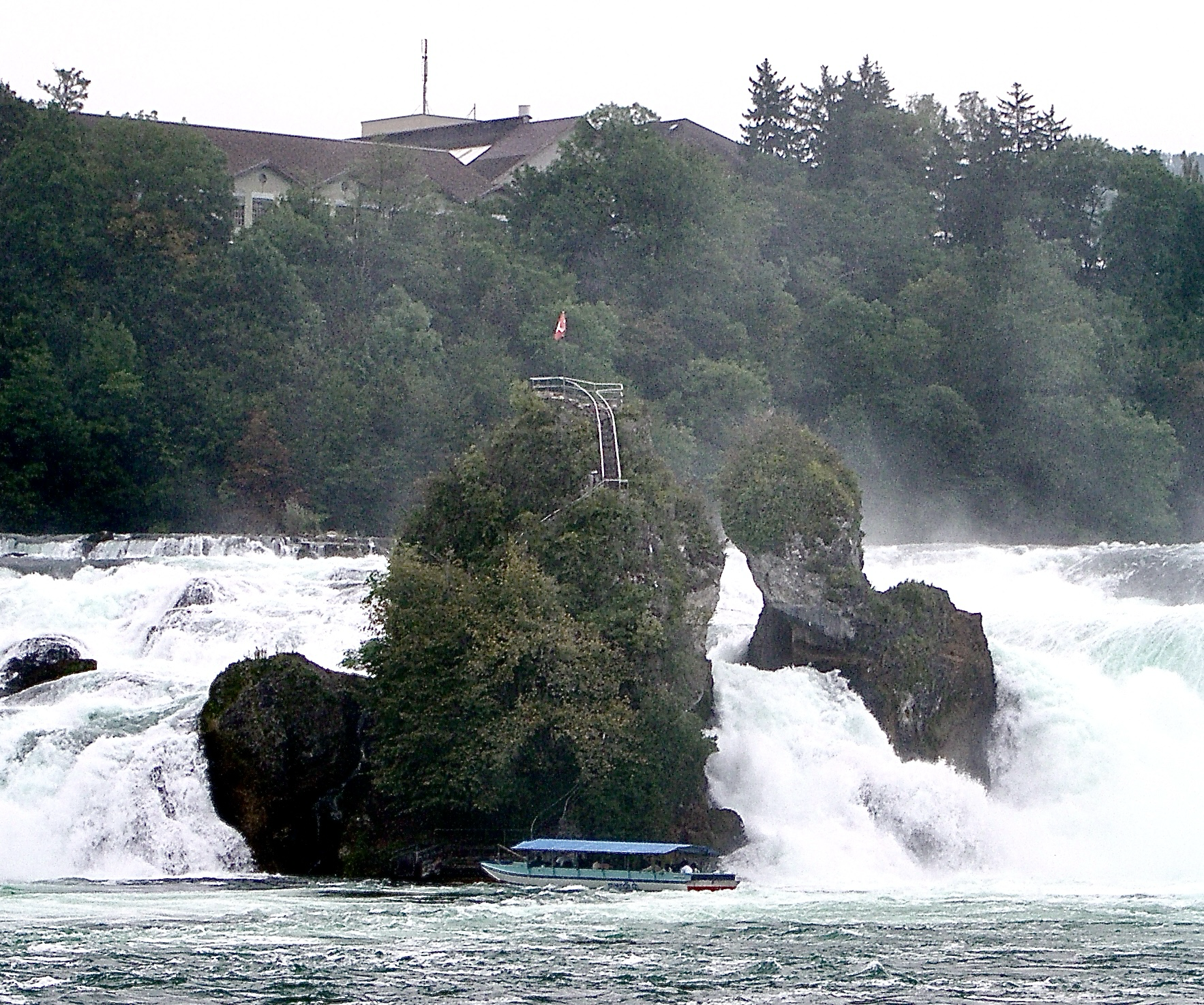 Ein kleines Schiffchen kämpft sich zu einen mitten im Rheinfall gelegenen Felsen, von dessen Spitze man in die tobenden fluten blicken kann Ein kleines Schiffchen kämpft sich zu einen mitten im Rheinfall gelegenen Felsen, von dessen Spitze man in die tobenden fluten blicken kann