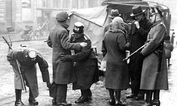 Gestapo men are searching a man on the street