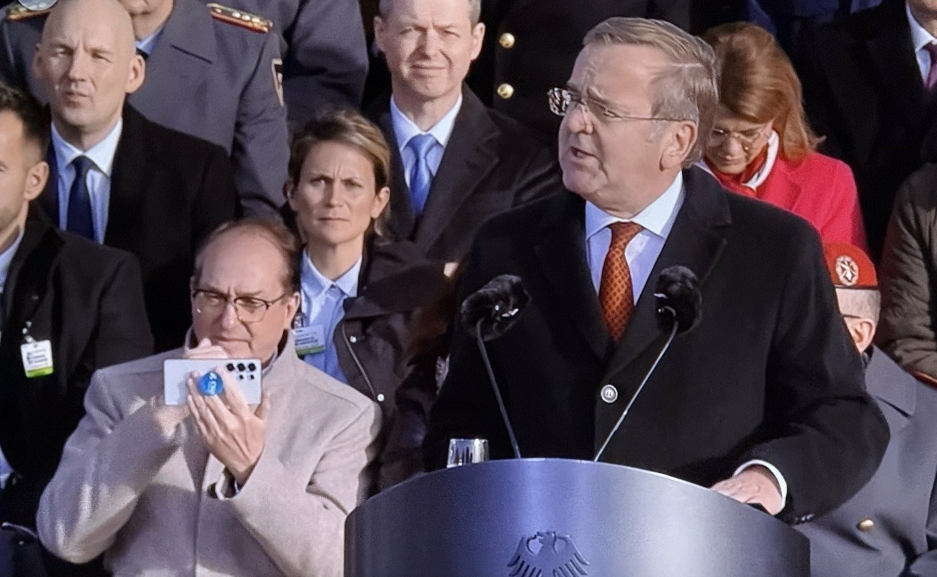Innenminister Dobrindt spielt, während einer Gelöbnisrede des Verteidigungsministers, auf dem Handy.
