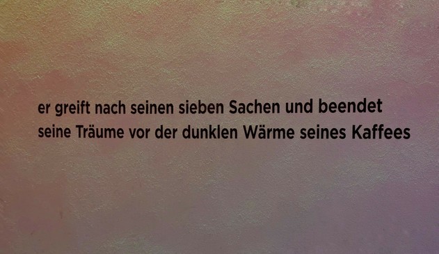 Der Spruch an der Wand:ner greift nach seinen sieben Sachen und beendet seine Träume vor der dunklen Wärme seines Kaffees