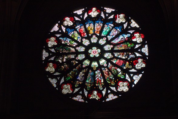 Neugotische Fensterrostett mit vielen bunten Glaslegearbeiten über christliche Symbolik uns Szenen.