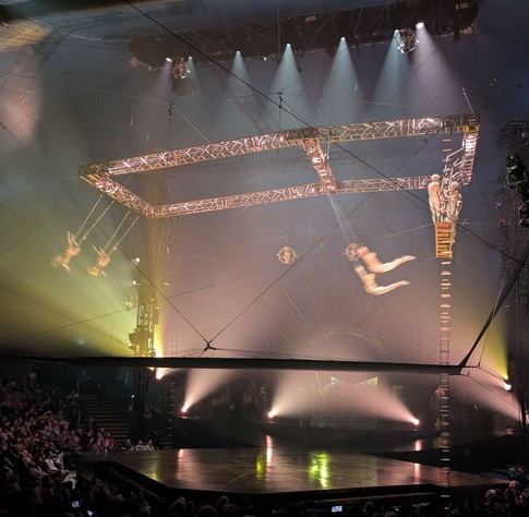 Trapeze.n4 Trapeze. 2 Fänger schwingen kopfüber hängend und zwei andere schwingen parallel nebeneinander in die Richtung der Fänger