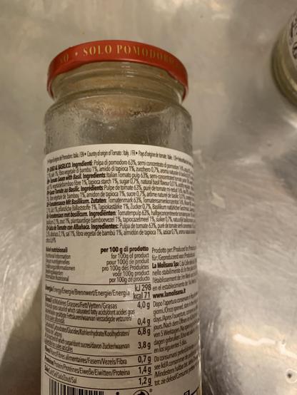 Ein leeres Glas Tomatensauce mit seinem Etikett und der Aufzählung der Inhaltsstoffe.