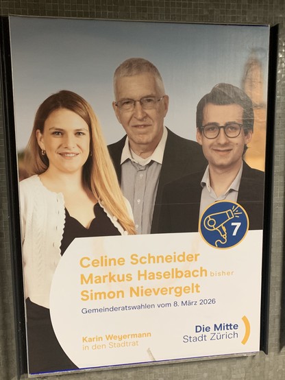 Ein Wahlplakat der Partei Die Mitte der Stadt Zürich mit einem Gruppenbild von zwei kandidierenden Männern und einer Frau. In einem Kreis ist ein stilisierter Föhn abgebildet, daneben die Zahl sieben.