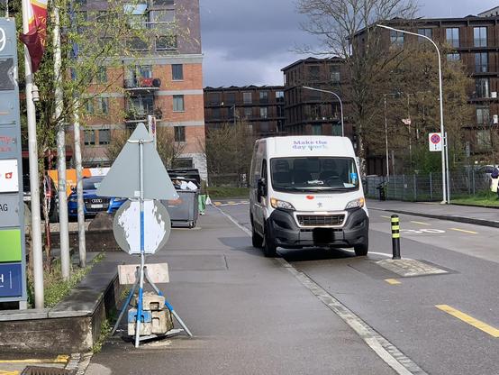 Ein weisser Lieferwagen steht dort, wo auch für den Fahrer offensichtlich die Einfahrt zum Radstreifen beginnt. Im Hintergrund eine Wohnsiedlung.