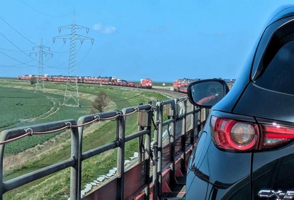 auf dem Hindenburgdamm kommen sich 2 beladene Autozüge entgegen. Sonne und blauer Himmel, Marsch links und rechts 