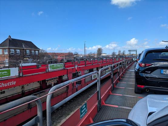 mehrere Wagen eines Autozuges. Einer davon voll mit Autos