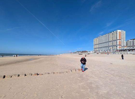 Sandstrand mit blauem Himmel und rechts ein großes Hotel mit vielen vielen Stockwerken