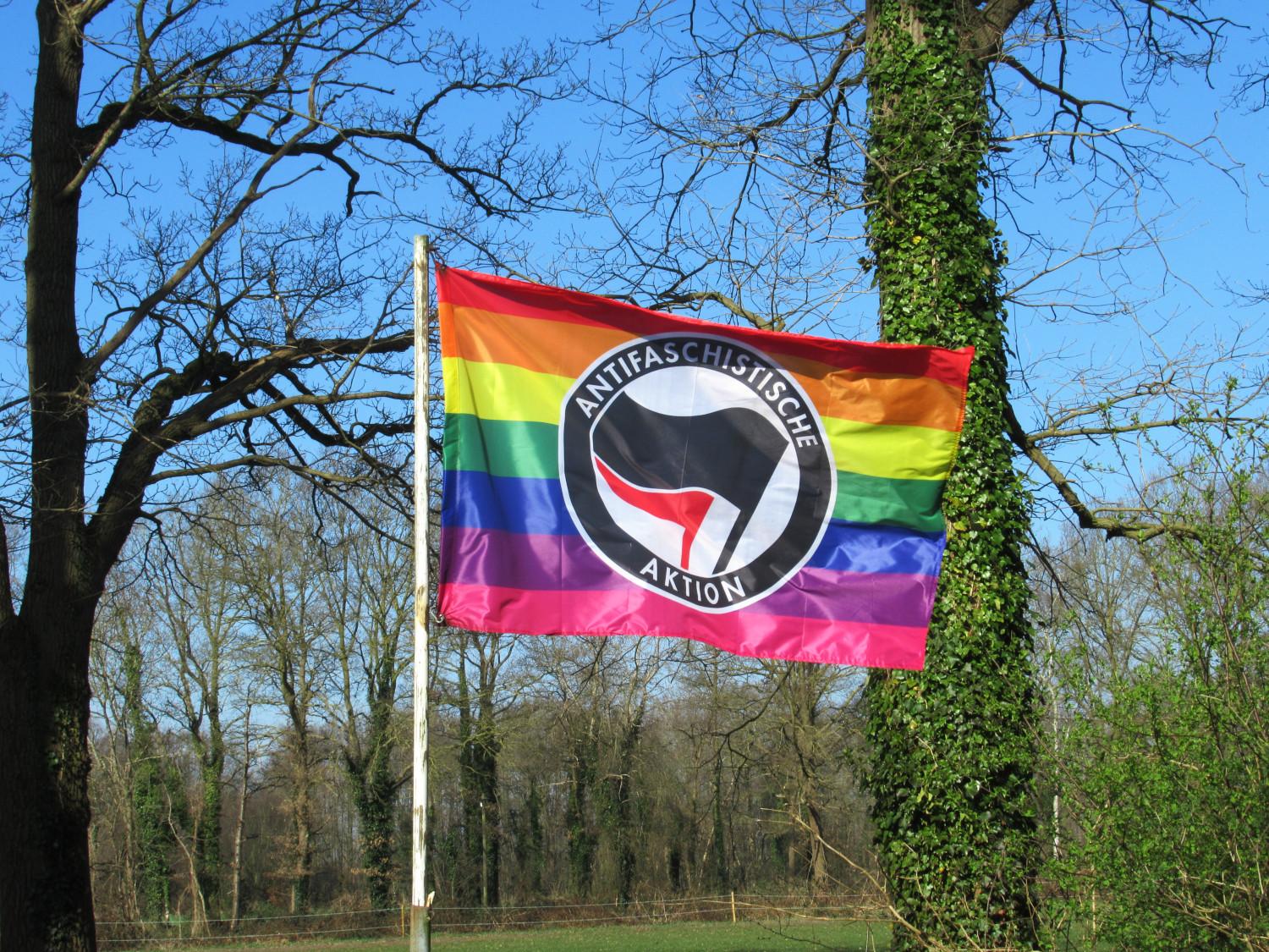 Regenbogen-Antifa-Fahne vor blauem Himmel