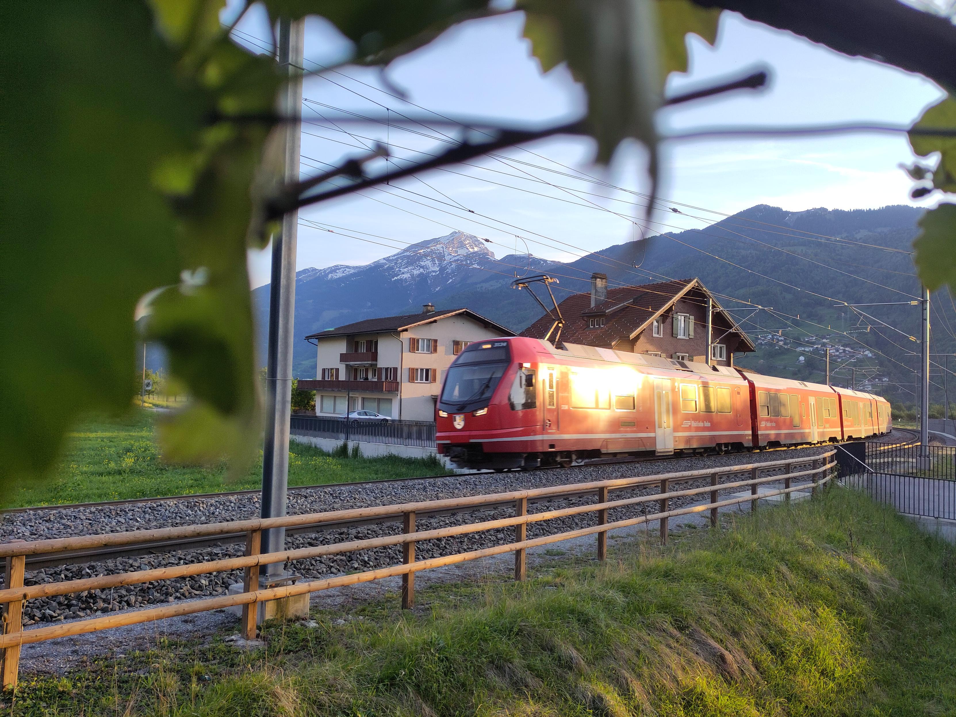 Foto. Ein roter Zug in Berglandschaft.