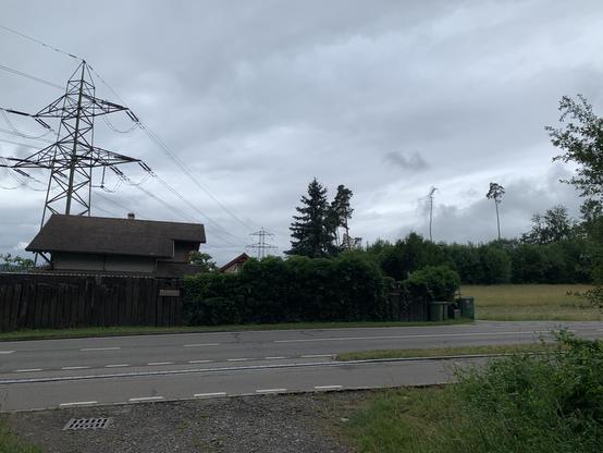 Links das Bahnwärterhäuschen von der entgegengesetzten Strassenseite. Laut Landeskarte liegt bis hier ein Gleis.