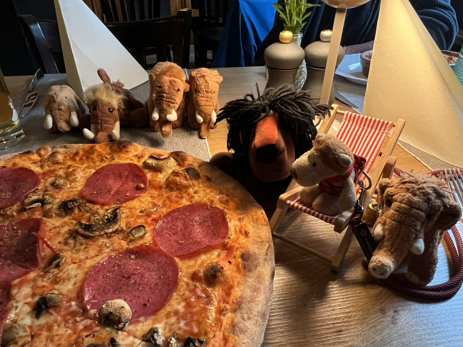 Die vier plüschigen Mammuts, Ludwig, noch ein Mammut und ein Löwe mit einer Pizza
