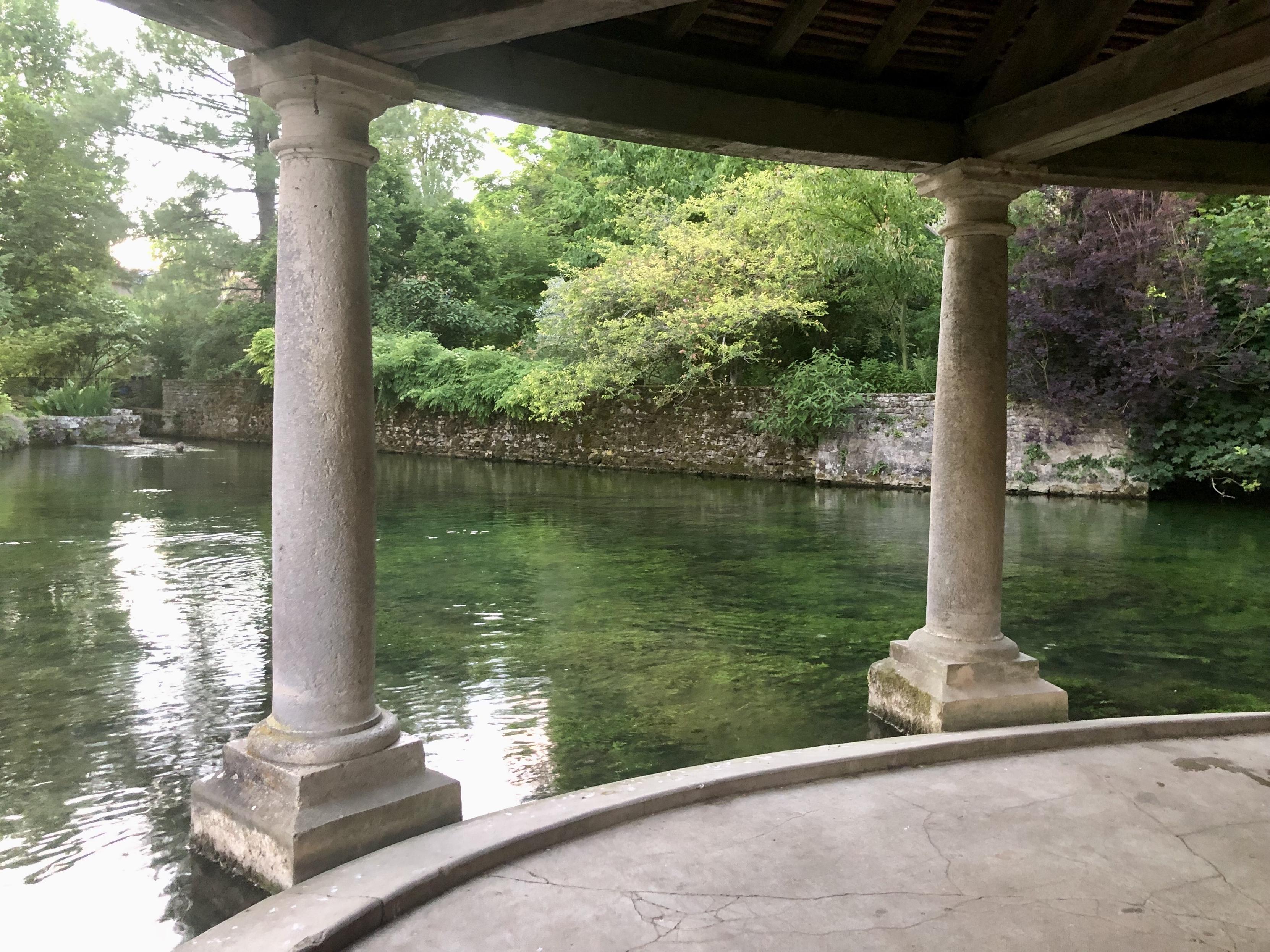 Blick zwischen Säulen hindurch vom Waschhaus auf den klaren Fluss. Baujahr etwa 17. Jhd.