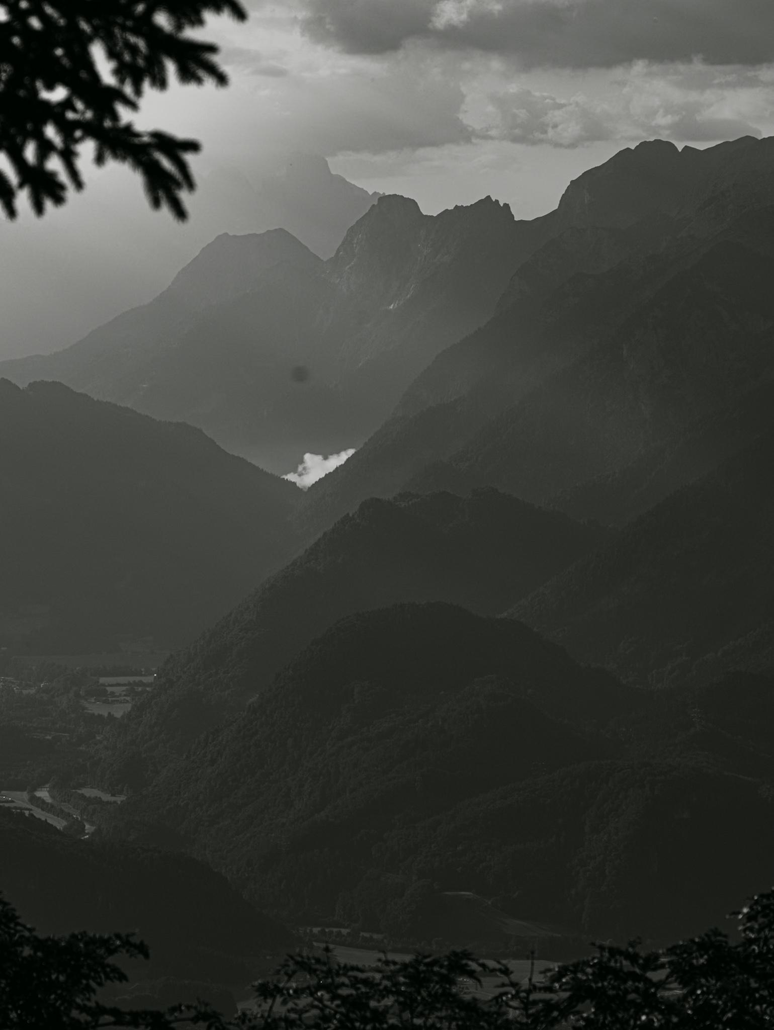 Blick von oben auf Berge und Täler 
Das Bild ist sehr dunkel und dunstig