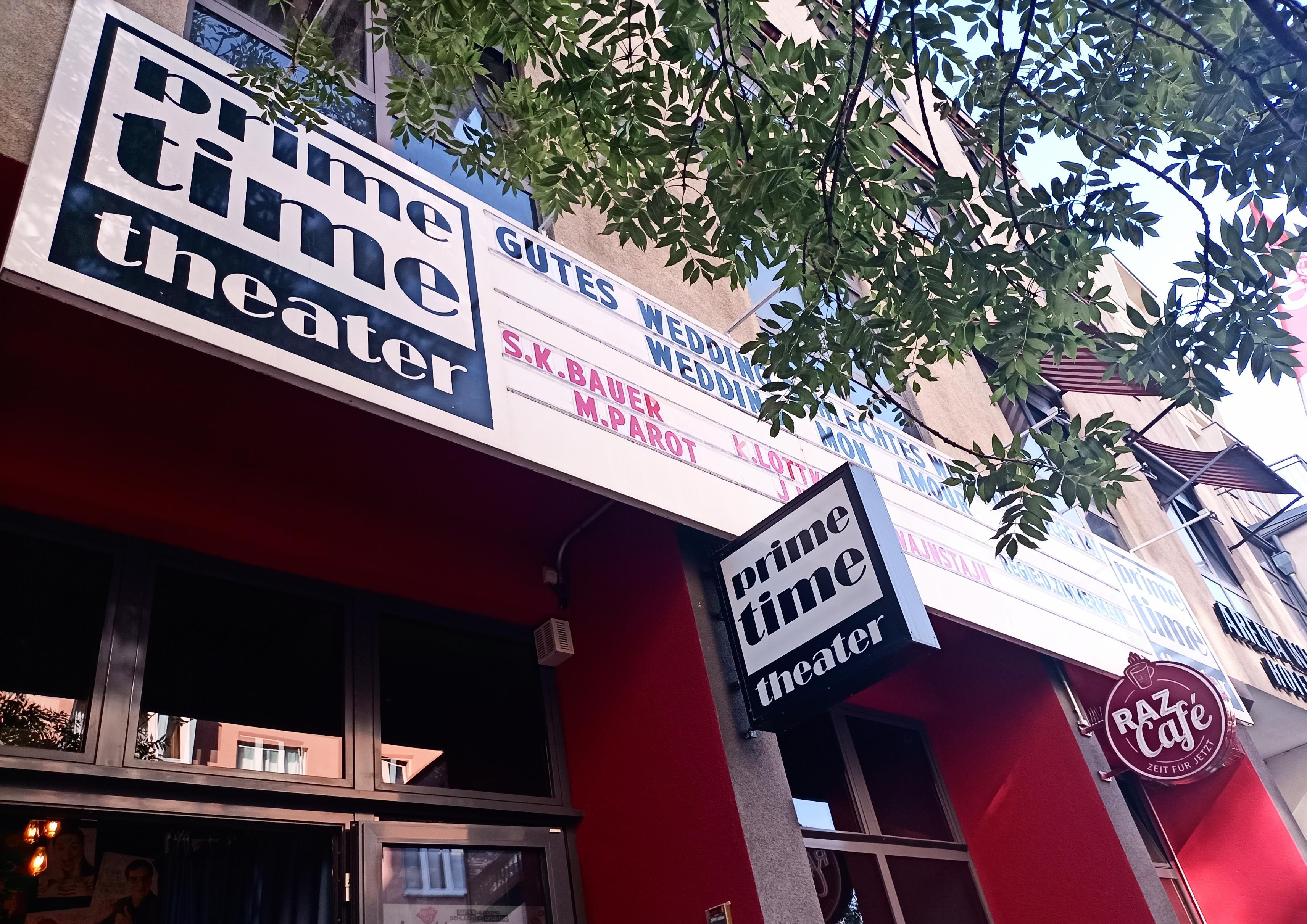 Über dem Eingang des theaters ein Schild mit der Ankündigung des Stückes