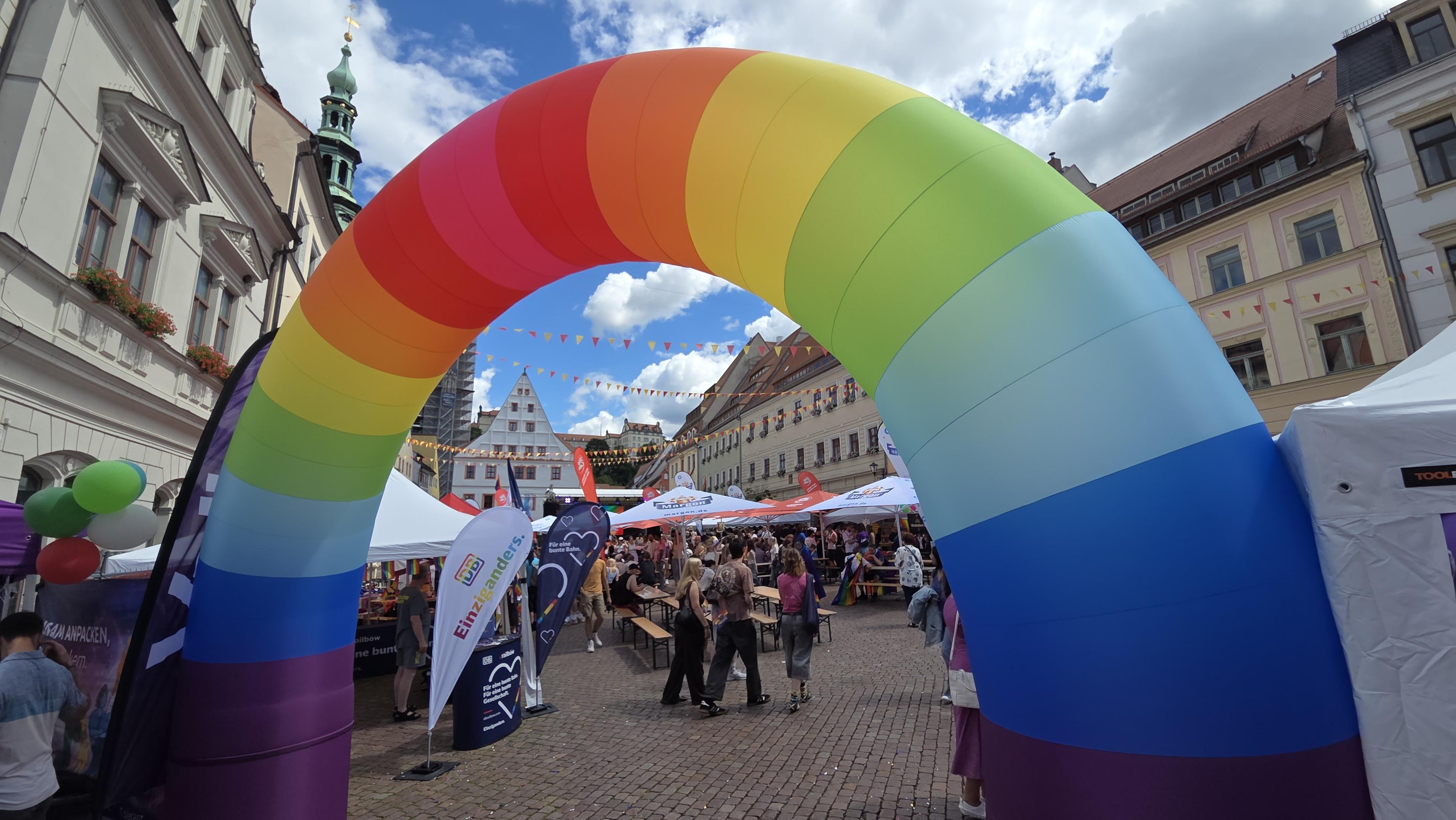Ein Bild vom Marktplatz Pirna. Am Zugang ein großes regenbogenfarbiges Tor.