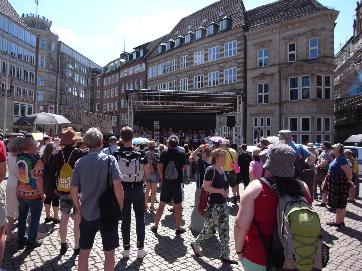Demo auf dem Marktplatz, Bühne, Schild seitlich sichtbar: Prüft alles und das Gute behaltet!