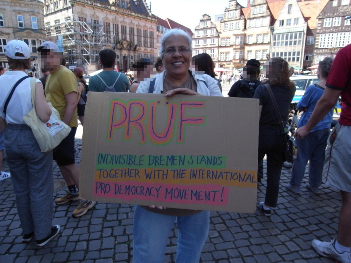 Indivisible  Schild: PRÜF
Indivisible Bremen stands together with the international pro-democracy movement!