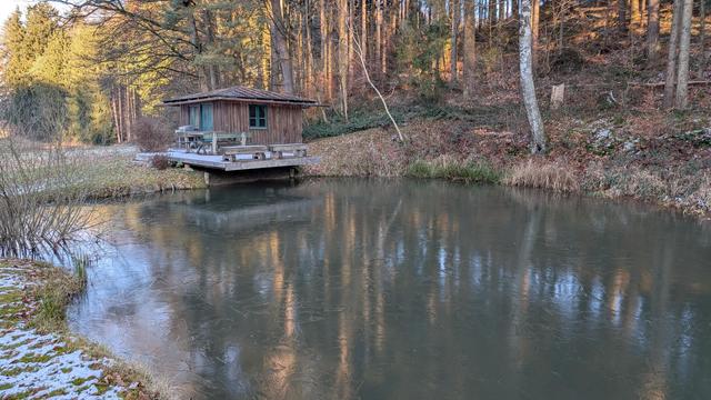 Hütte vor einem zugefrorenen Weiher