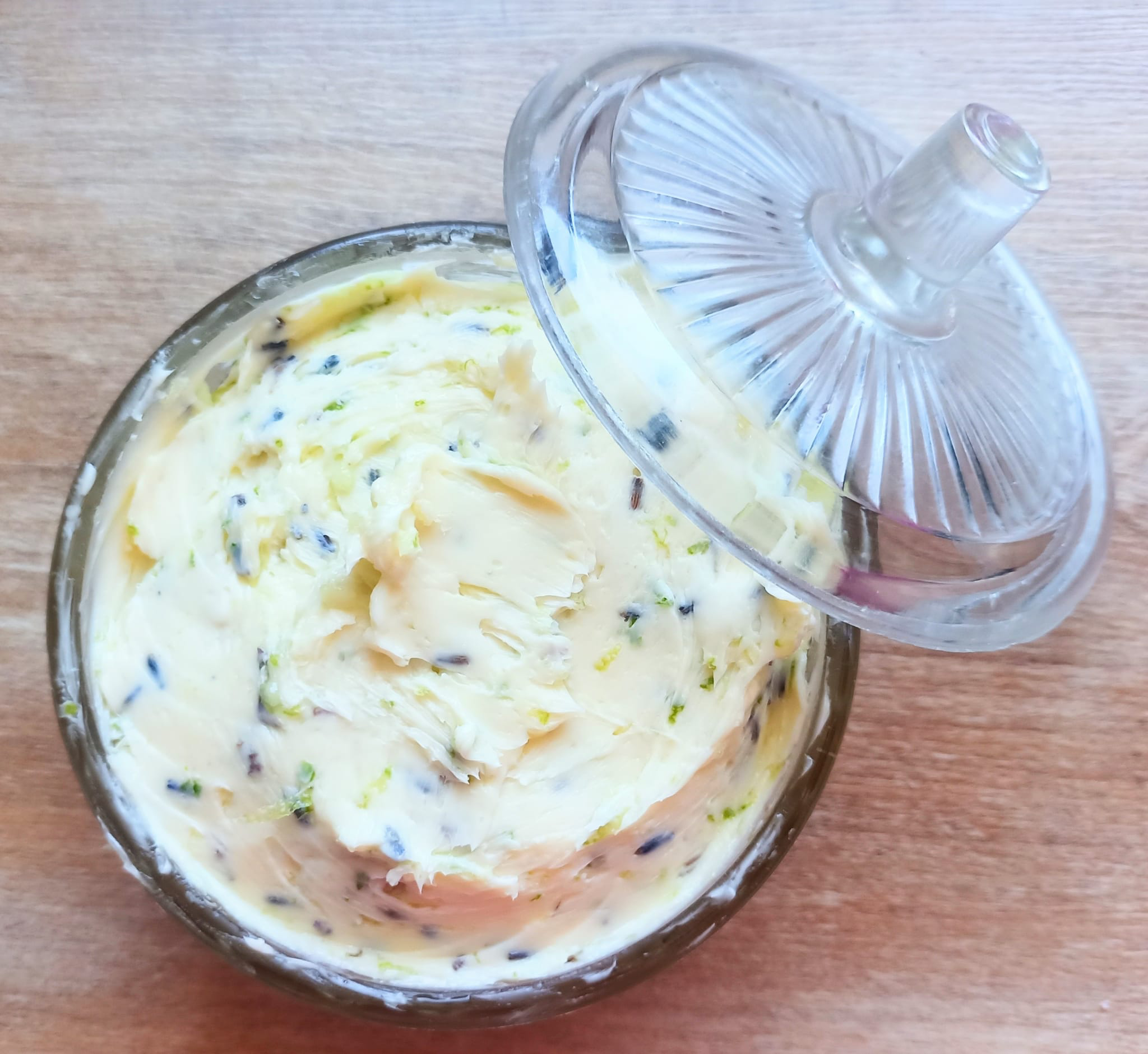 Die fertig gemischte Butter in einer Glasschale, der Deckel liegt daneben.